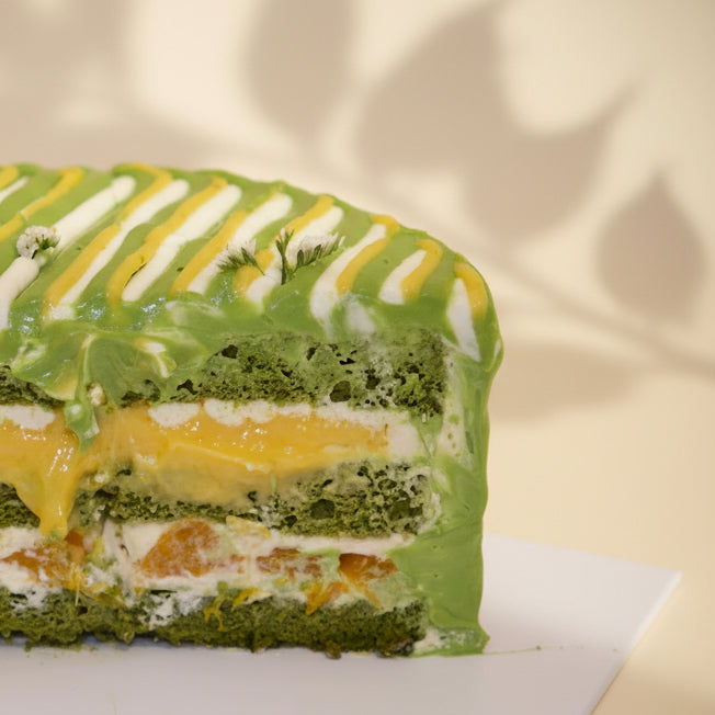 Cross-section of Jasmine Lime Citrus Matcha Cake by at sucré Singapore - vibrant matcha cream layers
